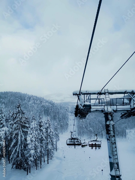 Fototapeta A view from a ski lift on a snowy mountain