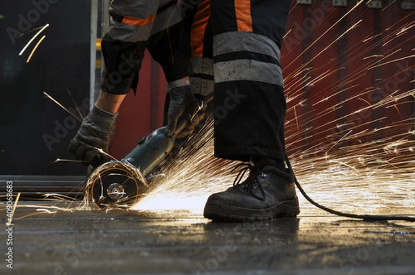 Obraz Worker at the factory cuts metal. sparks.