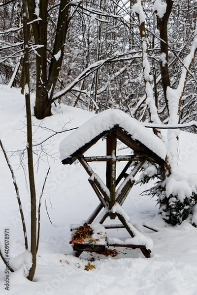 Obraz View on a feeder for wild animals in forest in winter