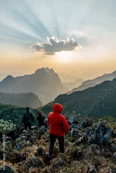 Fototapeta Adventurers wearing a red hoodie with mountains and dusk near the sunset in the background of Doi Luang, Chiang Dao, Chiang Mai, Thailand. Taking a photo from the summit.