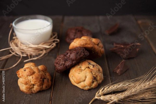 Fototapeta Cookies on a wooden table with a glass of milk and wheat ear