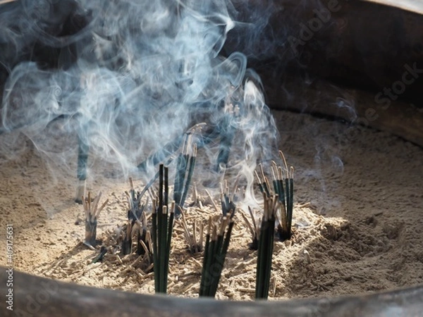 Fototapeta お寺の燭台で燃える線香