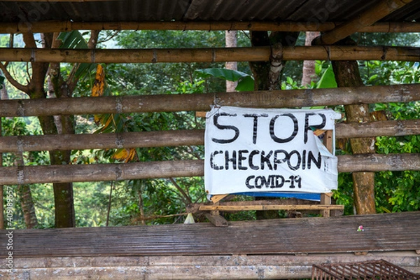 Fototapeta Stop Checkpoint Covid-19 rustic sign banner on wooden stand. South Asia anti covid measures. Travel ban in Philippines. Stop banner template. Covid checkpoint in rustic village. Virus pandemic action