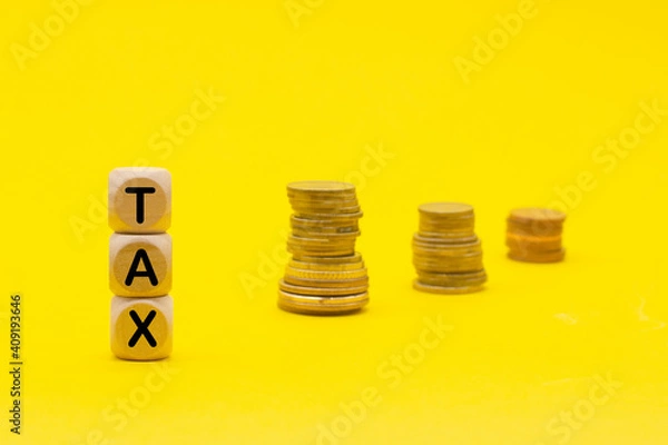 Fototapeta Wooden cubes with the word Tax on money climbing staits, pile of coins on yellow background ,Tax Concept