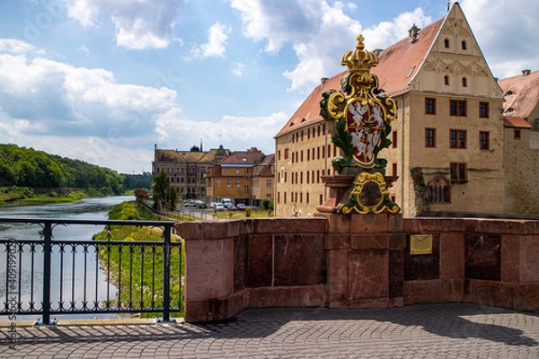 Obraz View of the "Poeppelmannbrücke" bridge in Grimma, which was heavily damaged and rebuilt during the flood in 2002, with historical coat of arms, Germany b