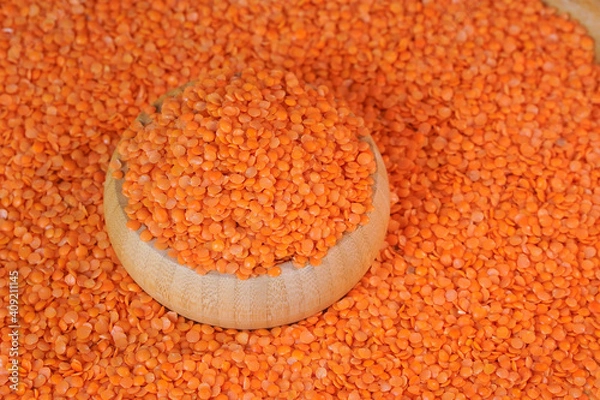 Obraz Red lentils in wooden container  top view.  Peeled lentil seeds. High protein product. The legume family. Healthy organic food diet concept. Marketing, advertising use. Studio shot.