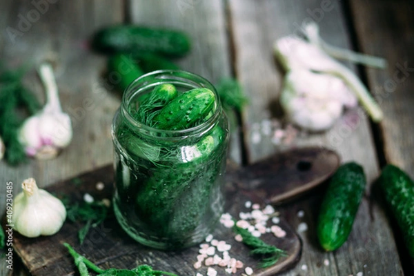 Fototapeta Cucumbers in a jar The process of pickling fresh cucumbers.