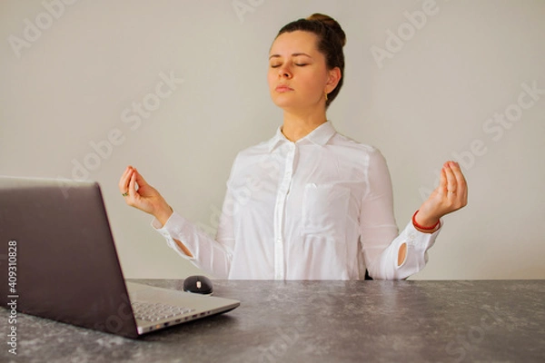 Fototapeta Office worker meditates in front of the computer