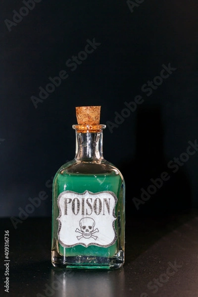 Fototapeta Concept of toxic thing. Transparent bottle with purple liquid simulating poison. The label reads poison along with a skull and two tibias