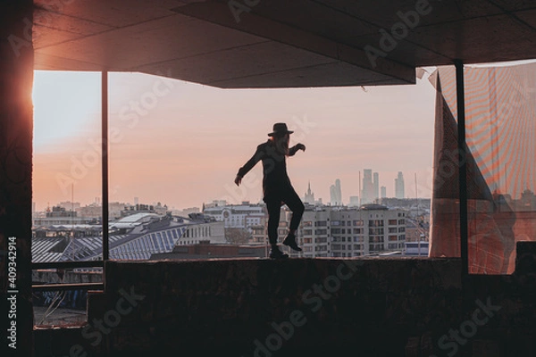 Obraz 
girl walks along the edge of the balcony