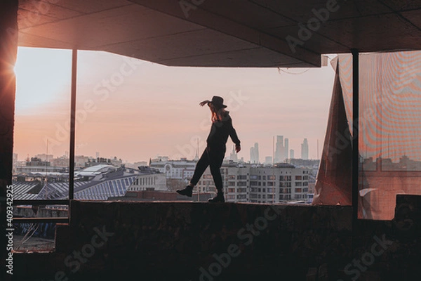 Obraz 
girl walks along the edge of the balcony