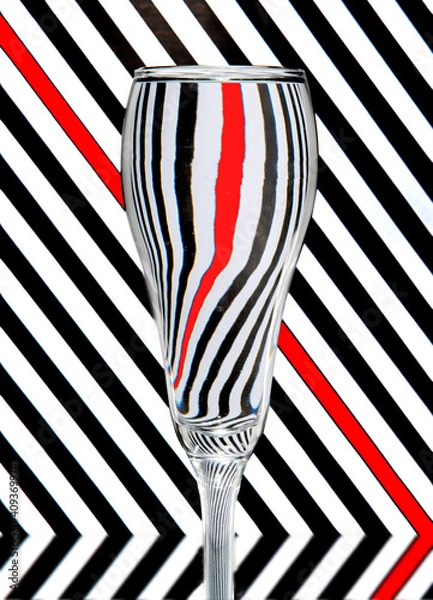 Obraz refraction of light by a wine glass on a black and white striped background. Abstract glass art.