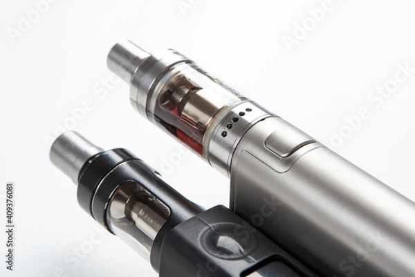 Fototapeta Two Electronic Cigarette close-up. Fragment of Electronic Cigarette on a white background. Vaping cigarettes. Devices for smoking steam. Cigarettes are modern. Concept devices from vape shop