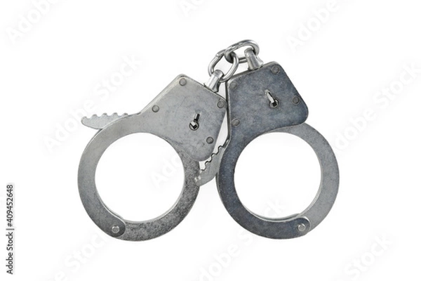 Fototapeta Police handcuffs isolated on white background with light shadows. Pair of real metal handcuffs macro close-up high resolution.