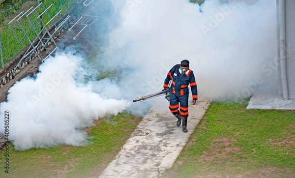 Fototapeta Healthcare worker using Fogging machine spraying chemical to eliminate mosquitoes and kill larvae to fight against the spread of dengue fever, Zika virus or Malaria at a residential area.