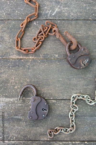 Obraz Two old rusty padlock and rusty chain on wooden background in steampunk style. High quality photo