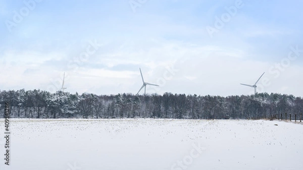 Obraz Drei Windräder im Winter hinter einem verschneiten Wald