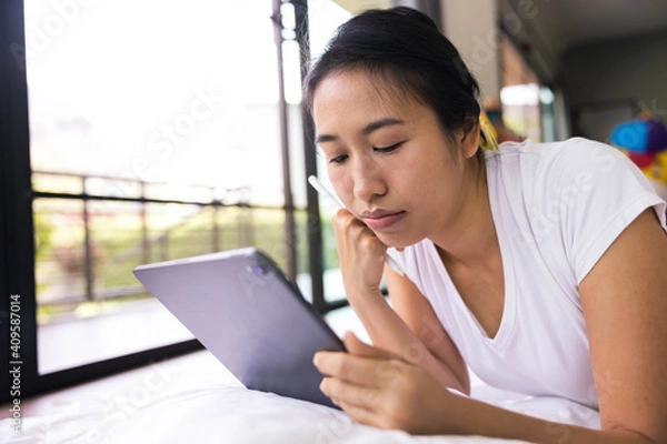 Obraz woman using digital tablet in a bed at home. The use of concept of new generation, family, parenthood, authenticity, connection, technology.