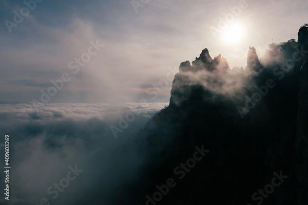 Fototapeta mountain peak above the clouds at the misty morning