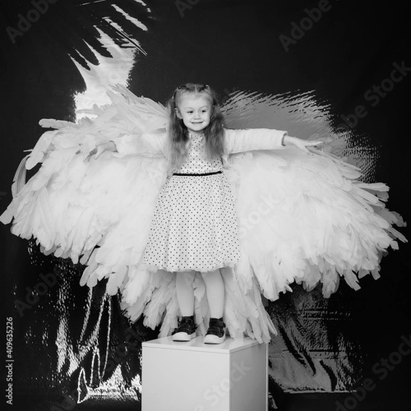 Obraz little girl 4 years old in white angel wings on a red latex background in the studio for valentine's day