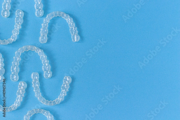 Obraz Invisalign braces or invisible retainer on blue background