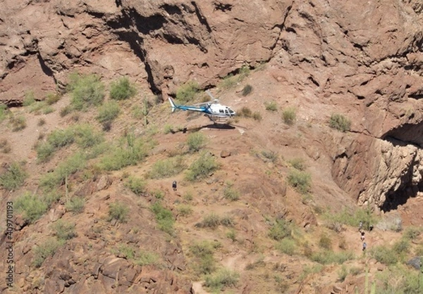 Obraz View of a hiker being airlifted from a dangerous situation on Camelback Mountain using a Phoenix Police helicopter in Arizona
