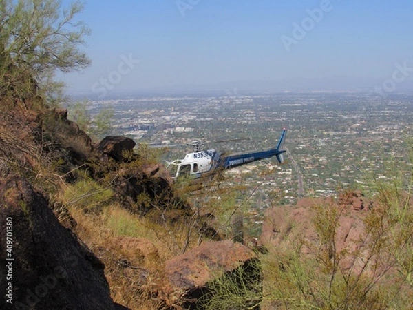 Fototapeta View of a hiker being airlifted from a dangerous situation on Camelback Mountain using a Phoenix Police helicopter in Arizona