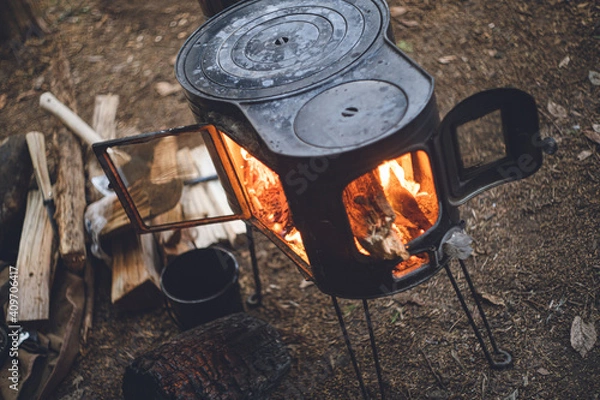 Obraz 薪ストーブの焚き火。杉の森の中の冬のキャンプ。