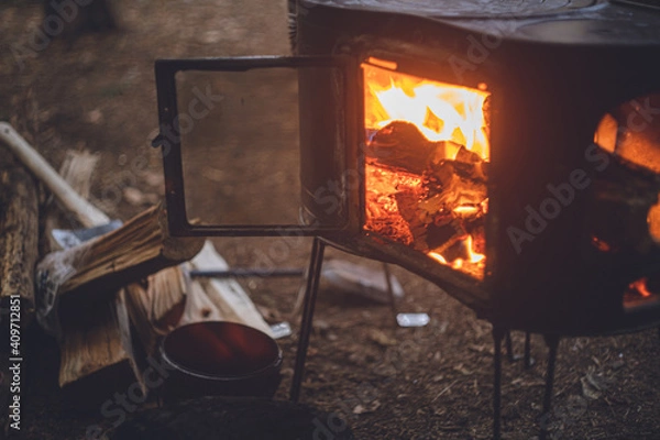 Obraz 薪ストーブの焚き火。杉の森の中の冬キャンプ。