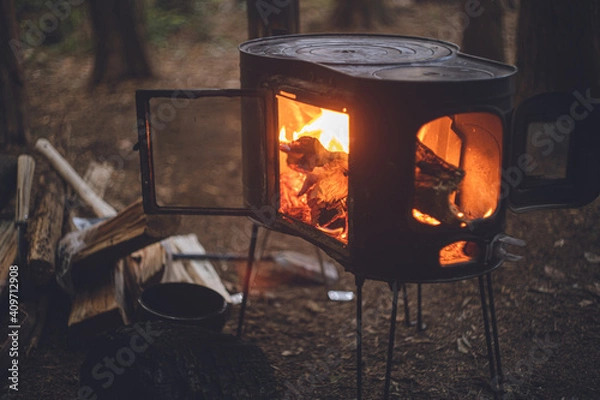 Obraz 薪ストーブの焚き火。杉の森の中の冬キャンプ。