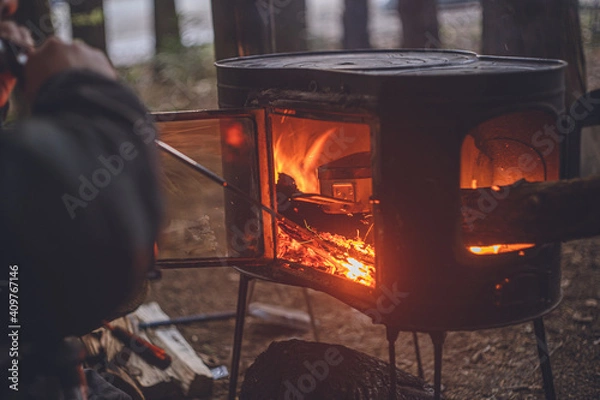 Obraz 冬のキャンプ。薪ストーブに火吹き棒で火力を上げる。