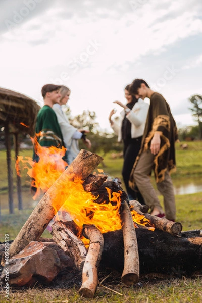 Fototapeta A group of friends enjoying an afternoon in the countryside - A group of young friends happily relaxing and enjoying a campfire.