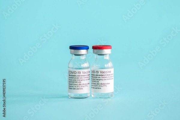 Fototapeta Ampoules with a vaccine against coronavirus infection close-up on a light blue background