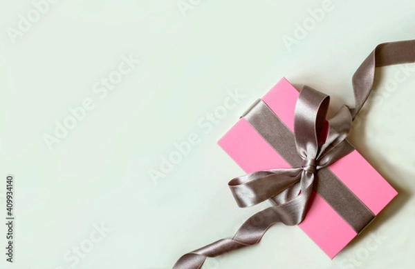 Obraz white background with pink gift box and silver bow