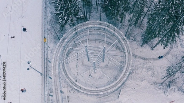 Fototapeta Speed Fun rodelbahn in the forested area in mountains. ski resort on winter daytime Background of spruce forest in snow. Concept of active, extreme winter recreation in mountains.Top Shot. 4K 