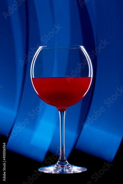 Obraz Rounded cocktail glass with a red alcoholic drink on a black background with a light pattern. Light blue drawing.