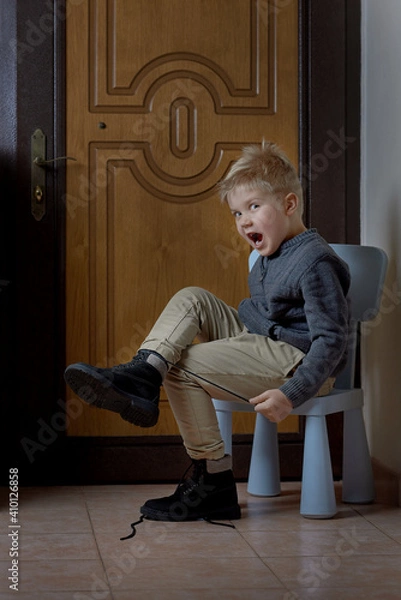 Fototapeta Preschooler child learning to tying shoelace at home, selective focus. Vertical format