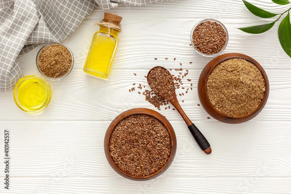 Obraz Flaxseeds in a spoon and bowl with a bottle of flaxseed oil and flaxseed flour