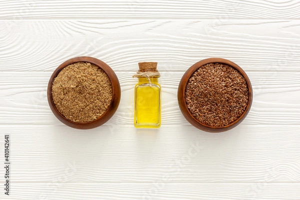 Obraz Flaxseeds in a spoon and bowl with a bottle of flaxseed oil and flaxseed flour