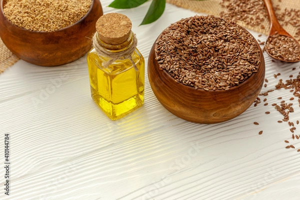 Fototapeta Flaxseeds in a spoon and bowl with a bottle of flaxseed oil and flaxseed flour.