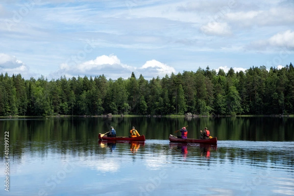 Fototapeta People in life vests canoeing on a lake in National Park. Summer sunny day. Camping, portaging, adventure, summer activities concept.