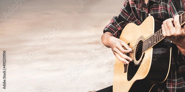 Fototapeta Close up a man's hands playing acoustic guitar with copy space for text. Pamorama playing acoustic guitar at a recording studio.