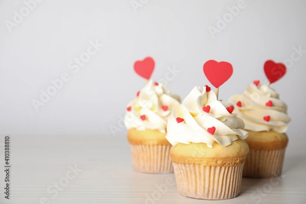 Fototapeta Tasty sweet cupcakes on white table, space for text. Happy Valentine's Day