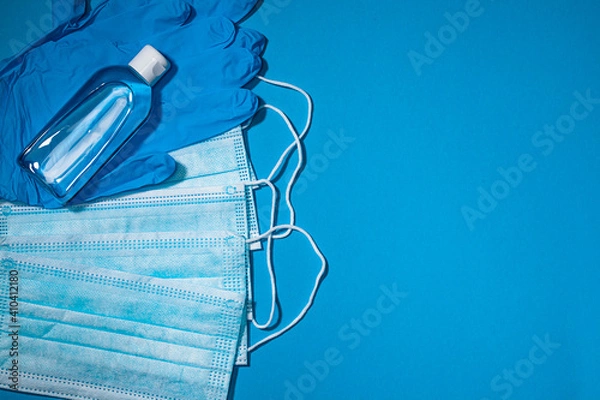 Fototapeta Medical gloves mask and alcohal gel for protecting infection during Coronavirus pandemic top view on light blue banner background with copy space