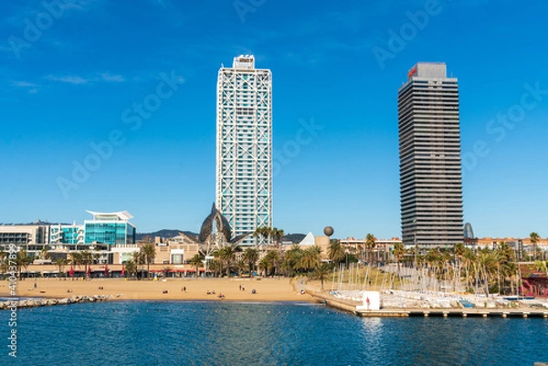 Fototapeta BARCELONA, SPAIN, FEBRUARY 3, 2021: Famous towers of the port of Barcelona, the Mapfre Tower and the Hotel Arts. Sunny winter day. During the covid-19 pandemic. Barcelona Skyline.