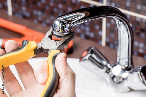 Obraz plumbing faucet repair concept. plumber using wrench tool and pliers to adjusting tap leak at bathroom. diy plumber conceptual