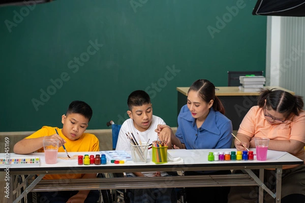 Obraz Asian disability boy learning color Painting in classroom with Autism girl in special school with female teacher.