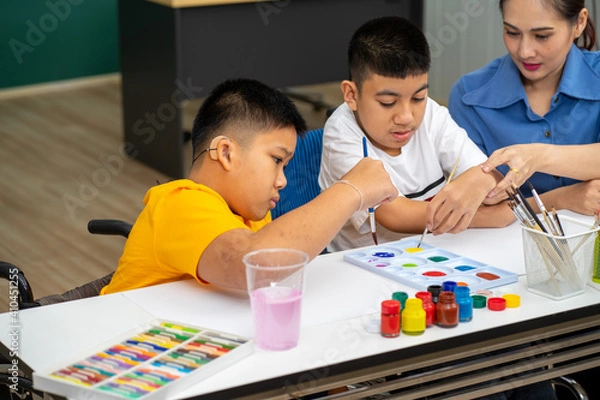 Obraz Asian disability boy learning color Painting in classroom with Autism girl in special school with female teacher.
