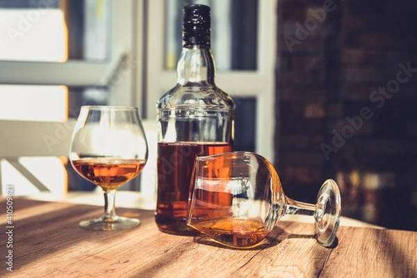 Fototapeta bottle of brandy and two glasses of alcohol in a bar