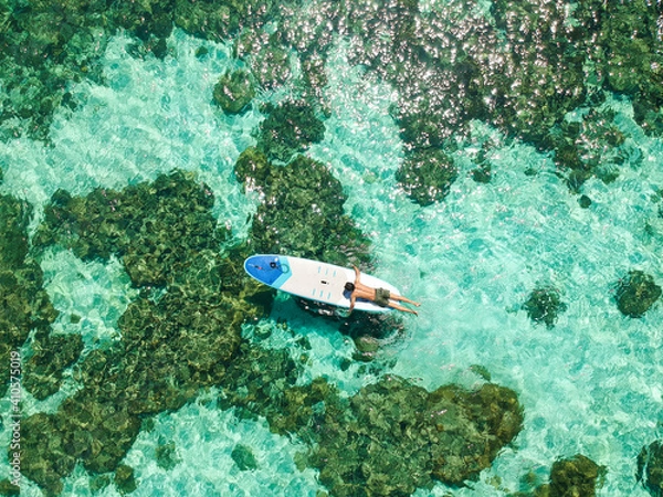 Fototapeta A man was doing paddleboard surfing on the surface of the water at Koh Lipe, Thailand.